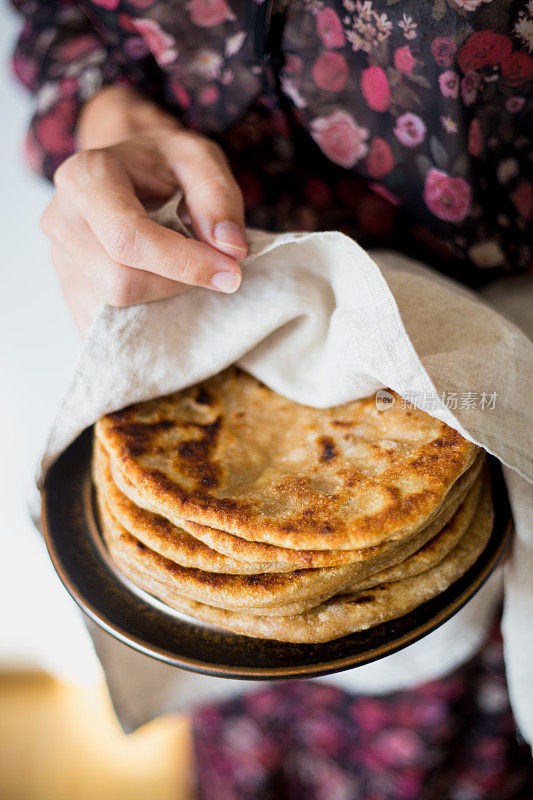 妇女拿着传统的印度面包- Aloo paratha或aalu paratha，土豆填充面包